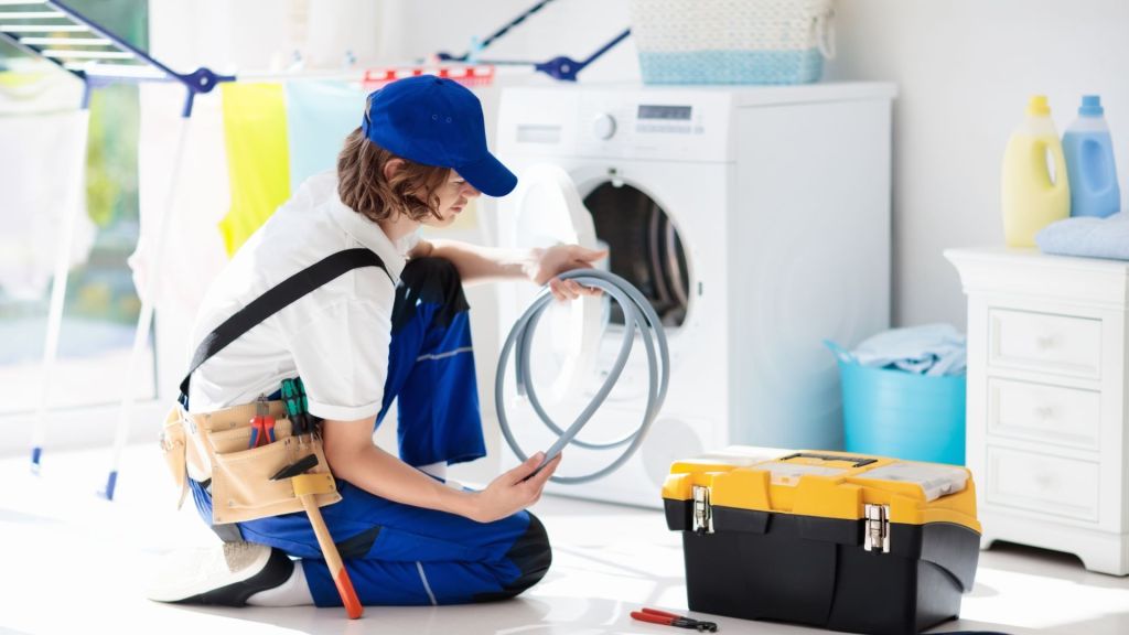 A woman fixes a btplen washing machine.