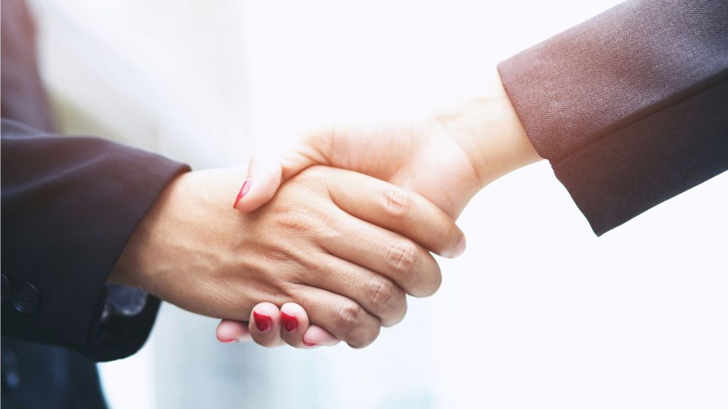  man and woman shake hands, suggests business deal.