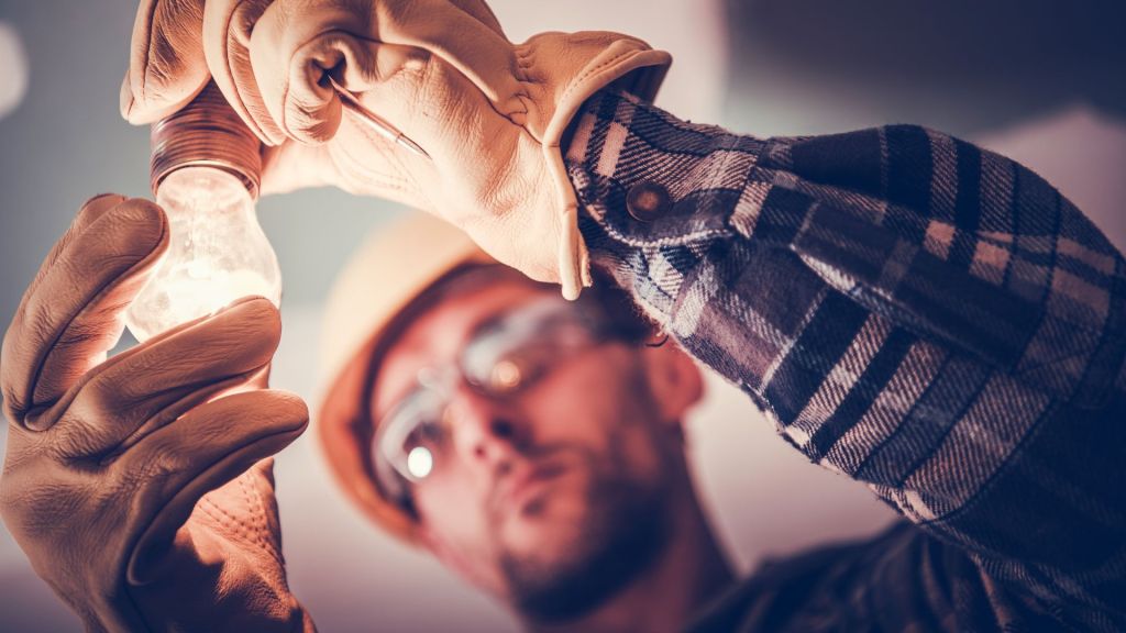 An electrician fitting a lightbulb.