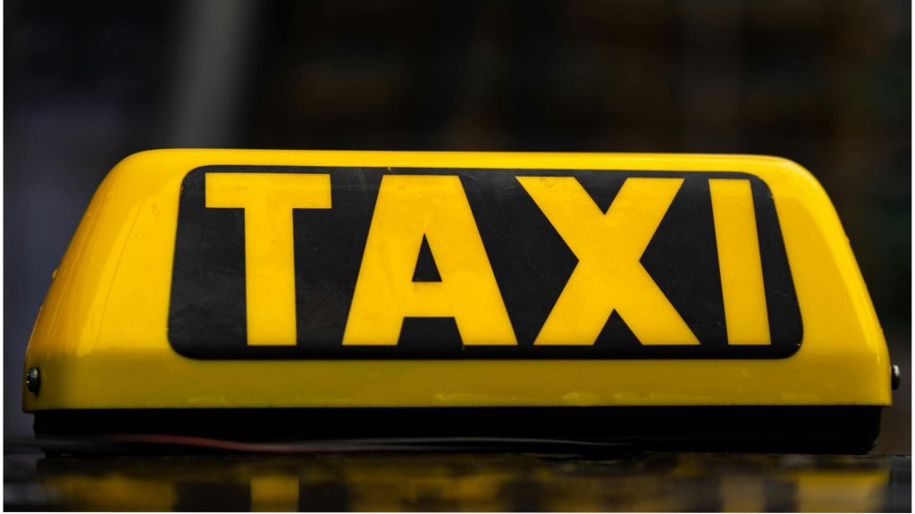 A yellow taxi sign on a dark blurred background. Relates to a story about a fake taxi roleplay.